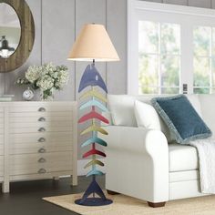 a living room filled with furniture and a lamp on top of a wooden table next to a white couch