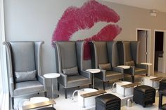 a salon with chairs and stools that have lipstick painted on the wall