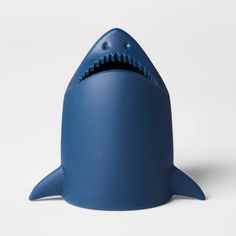 a blue shark shaped toothbrush holder on a white surface