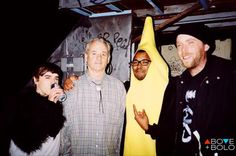 three men standing next to each other in front of a banana