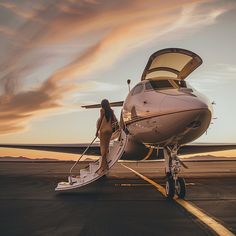 a woman stepping out of an airplane onto the tarmac