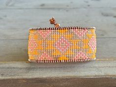 an orange and yellow bracelet on a wooden surface