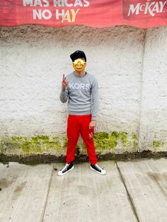 a person wearing a mask standing in front of a wall