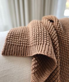 a close up of a knitted scarf on a couch