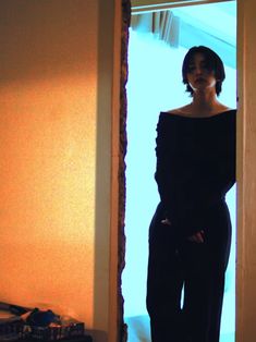 a woman standing in front of a doorway with her hands on her hips and looking at the camera