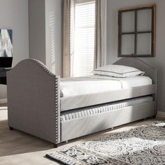 a bed sitting on top of a wooden floor next to a table