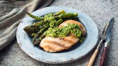 a plate with chicken, asparagus and broccoli on it