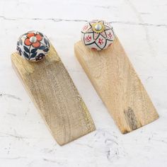 two wooden pegs with decorative knobs on them