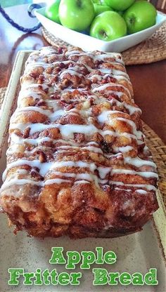 an apple fritter bread is sitting on a table next to some green apples