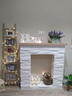 a white fireplace with candles and pictures on the mantle