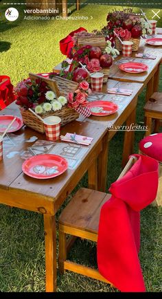 the table is set with red plates and pink napkins on it, along with other decorations