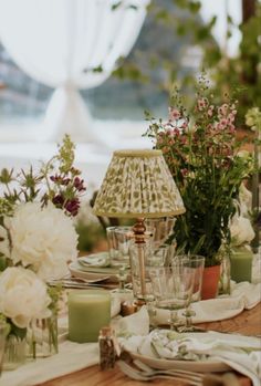 the table is set with flowers and candles