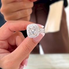 a close up of a person holding a diamond ring