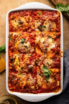 a casserole dish with meat, cheese and sauce in it on a table