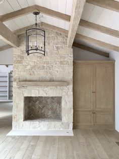 an empty living room with a fireplace and wooden floors