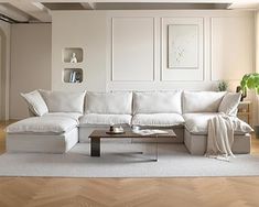 a living room with white furniture and wood floors