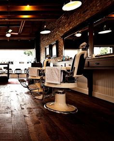 a barber shop with chairs and lights on the ceiling