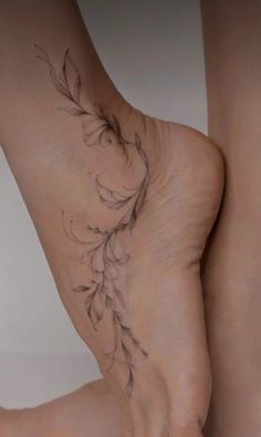 a woman's bare foot with a flower tattoo on the bottom of her leg