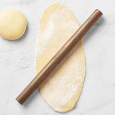 an uncooked dough and rolling pin on a white surface