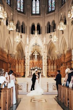 a bride and groom standing in front of the alter during their wedding ceremony at st patrick's cathedral