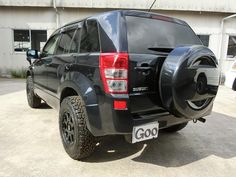 the back end of a black suv parked in a parking lot