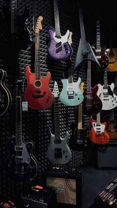 guitars and amps are lined up against a black wall in a music studio or recording studio