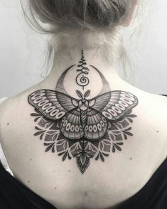 the back of a woman's neck with a moth tattoo on her left shoulder