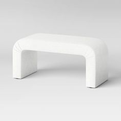 a white bench sitting in the middle of a room with no one on it's legs