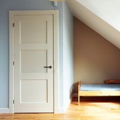 an empty room with a bed and a white door