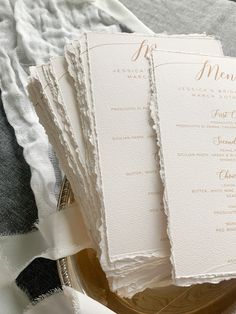 the wedding program is laid out on top of a gold platter with white linens