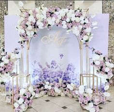 a floral arch with purple and white flowers