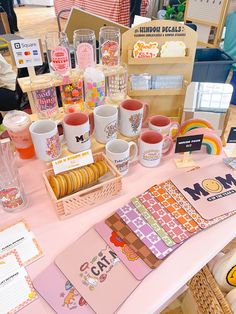 a table topped with lots of different types of cups and paper on top of it