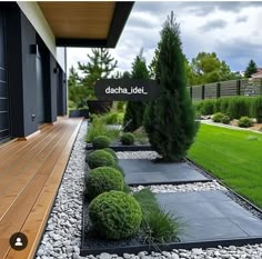 an outdoor garden with rocks and plants on the ground, along with a wooden deck