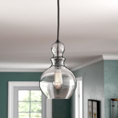 a clear glass light fixture hanging from a ceiling in a room with green walls and white trim