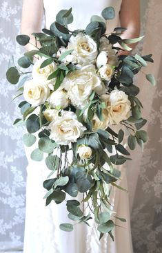 a bride holding a bouquet of white flowers