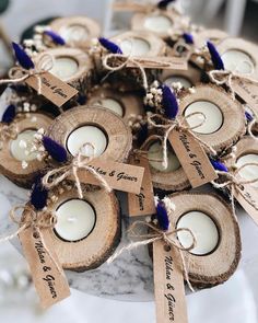 some white candles are sitting on wood slices