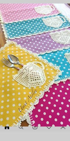 a table topped with lots of different colored placemats and utensils on top of each other