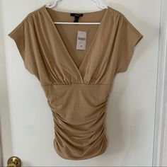 Tan Short Sleeve Shirt With Ruched Sides Stretchy Material Tighter Within The Body Sleeves Are Loose V Neck Nwt Casual Ruched Top For Date Night, Ruched Tops For Date Night In Spring, Spring Ruched Tops For Date Night, Summer Ruched Top For Date Night, Ruched Top For Date Night In Summer, Forever 21 Stretch Tops For Date Night, Pre-shrunk Short Sleeve Tan T-shirt, Brown Distressed Short Sleeve Top, Forever 21 Stretch Short Sleeve Top