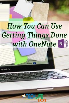 an open laptop computer sitting on top of a wooden table next to a pile of notepads