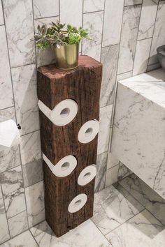 a toilet paper dispenser in the corner of a bathroom with marble tiles