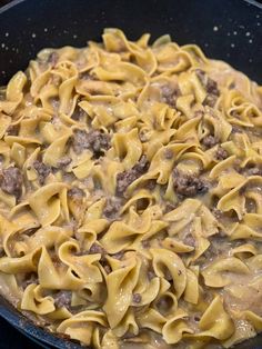 a skillet filled with pasta and meat