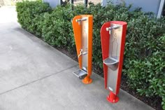 there are two orange and red urinals next to each other on the sidewalk