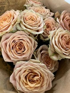 a bunch of pink roses in a paper bag