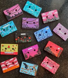 there are many different colored cassettes on the counter top, each with their own design