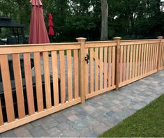 a wooden fence next to a brick walkway