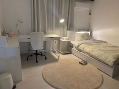 a bedroom with a bed, desk and chair next to a white rug on the floor