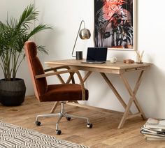 a desk with a laptop on it in front of a potted plant