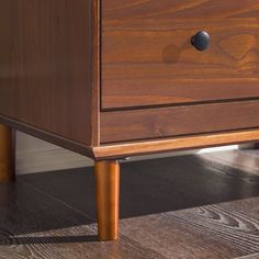 a close up of a wooden dresser on the floor