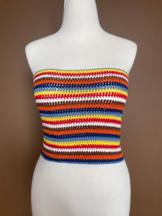 a white mannequin wearing a multicolored striped tube top on it's head