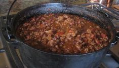 a large pot filled with chili sitting on top of a stove next to an oven